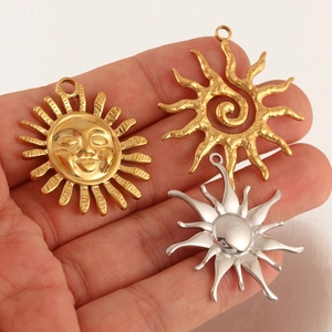 Detailed view of sun-shaped stainless steel pendants in gold and silver finishes