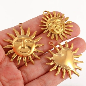 Handheld view of gold stainless steel sun and heart pendant charms for jewelry making