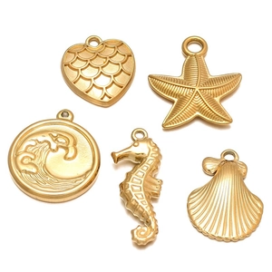 Detailed set of five matte gold ocean charms including seahorse, starfish and scallop