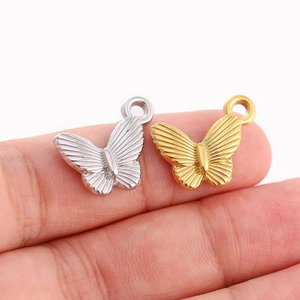 Détails de pendentifs papillon or et argent avec textures radiales et anneaux de suspension