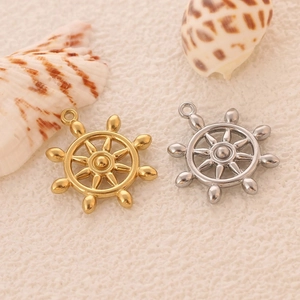 Close-up of gold and silver nautical steering wheel charms for DIY jewelry making