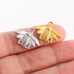 Détail macro de pendentifs abeilles en acier inoxydable doré et argenté pour bijoux DIY