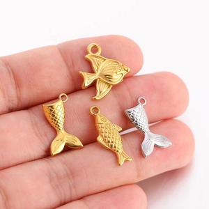 Pendentifs de poisson et queue de poisson en acier doré et argenté tenus à la main