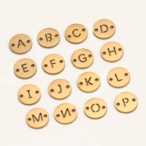 Close-up of golden brushed alphabet charms with dual-hole connectors for DIY jewelry