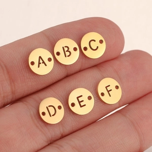 Close-up of golden hollow letter charms A-F with dual connector holes for DIY jewelry