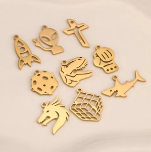 Set of 9 matte gold stainless steel pendants featuring rocket, alien, and shark designs