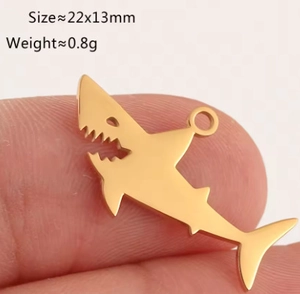 Close-up of golden shark pendant showing 22x13mm size and polished steel finish