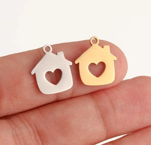Detailed close-up of polished house-shaped charms with heart cutout for DIY jewelry making