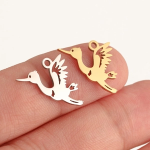 Detailed close-up showing gold and silver stork pendants with intricate hollow carvings