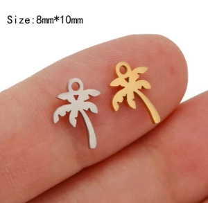Makroaufnahme von Gold- und Silberpalmen-Anhängern 8x10mm auf einer Fingerspitze