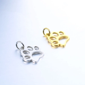Detailed view of polished stainless steel pet paw charms in gold and silver finishes