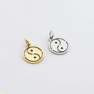 Macro detail of gold and silver stainless steel Yin Yang Tai Chi hollow charm pendants