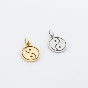 Macro shot of gold and silver hollowed-out yin yang tai chi pendants for jewelry making