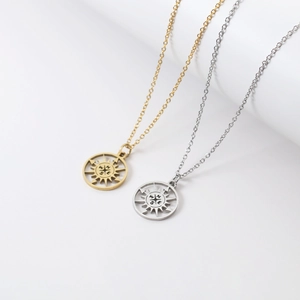 Detailed view of hollow compass pendants in gold and silver finish with NSEW engravings