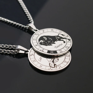 Macro shot of stainless steel Zodiac coin pendants featuring Leo and Taurus on Cuban chains