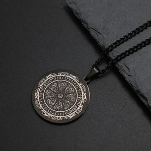 Détail macro du cercle de runes vikings sur un pendentif médaillon noir en acier inox