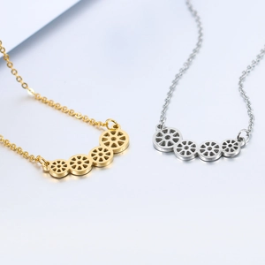 Close-up of geometric lotus-root pendants in polished gold and silver stainless steel