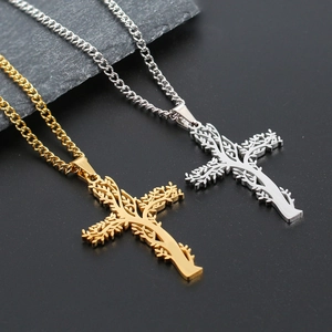 Détail des pendentifs croix arbre de vie en or et argent sur roche noire mate