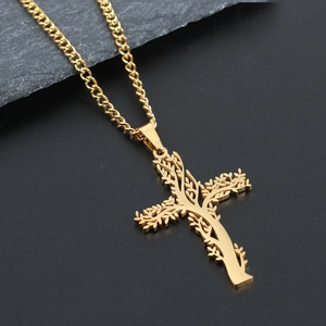 Macro d'un pendentif croix arbre de vie doré sur un fond de pierre sombre texturé