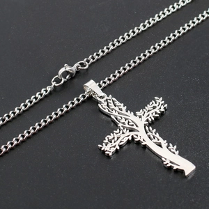 Détails macro du pendentif croix en acier inoxydable argenté avec motif arbre de vie
