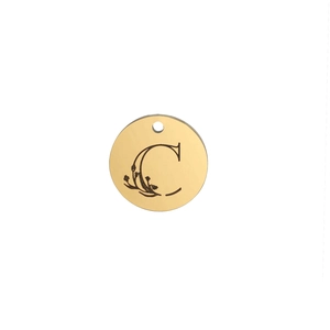 Macro detail of golden round pendant with floral engraved letter C and mirror finish