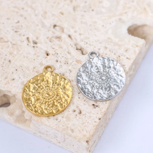 Hammered texture round sun pendant in gold and silver stainless steel on natural stone