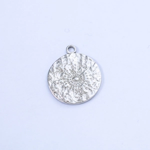 Detailed macro view of a silver sun engraved round pendant with textured hammer finish