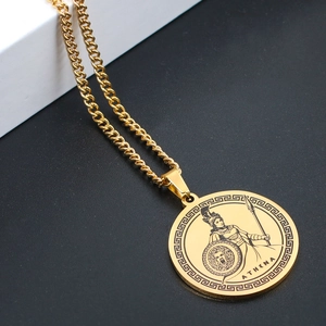 Detailed close-up of gold Athena goddess pendant featuring Greek key pattern and curb chain