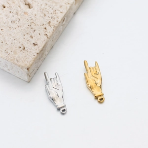 Vue détaillée de pendentifs geste d'amour or et argent sur décor en pierre