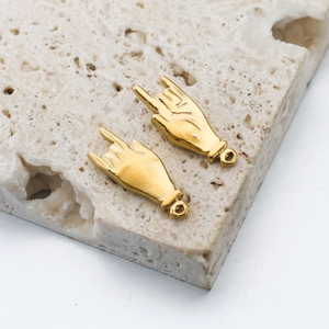 Détail de pendentifs main geste rock dorés pour bijoux DIY sur base en pierre