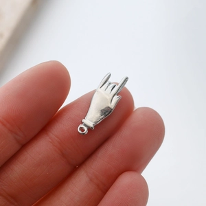 Gros plan d'un pendentif geste d'amour en acier inoxydable argenté pour la création DIY
