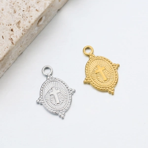 Macro detail of oval cross pendants in gold and silver finishes with beaded edges