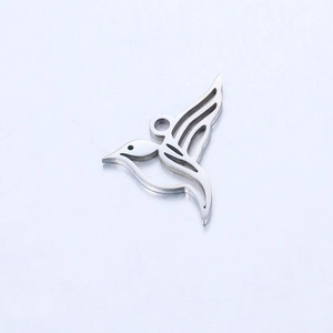 Macro detail of a mirror-polished stainless steel hummingbird pendant with hollow patterns