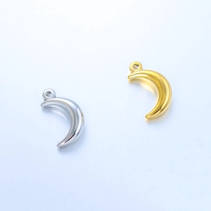 Macro detail of crescent moon pendants in polished gold and silver stainless steel