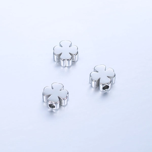 Macro shot of three polished stainless steel four-leaf clover beads for DIY jewelry making