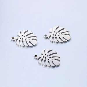 Macro view of polished stainless steel monstera leaf pendants for DIY jewelry making