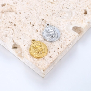 Detailed close-up of gold and silver scarab beetle pendant charms with intricate relief