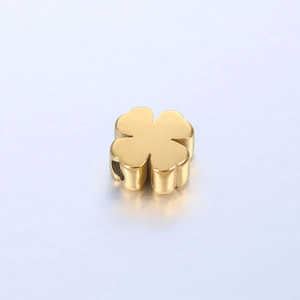 Close-up of polished golden 3D four-leaf clover bead for DIY jewelry making