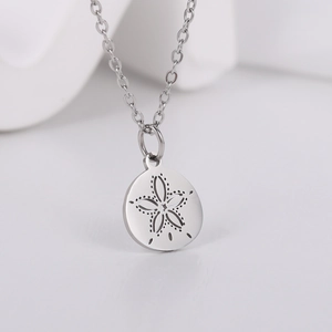 Macro detail of silver hollow flower pendant on a stainless steel chain necklace