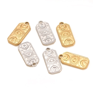 Detail view of rectangular sun and moon pendants in gold and silver stainless steel