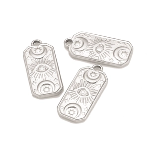 Macro view of stainless steel rectangular pendants with sun, moon, and celestial eye engravings