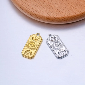 Detail of gold and silver rectangular sun moon and evil eye charms for DIY jewelry