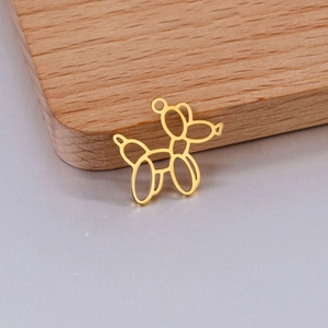 Macro view of a gold hollow balloon dog pendant charm on a wooden display stand