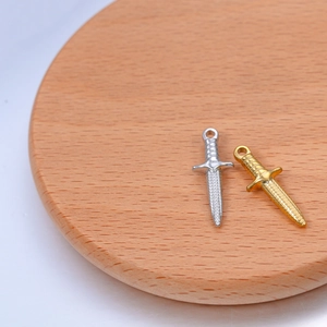 Detailed macro view of gold and silver sword pendants with diamond texture engraving