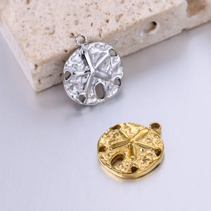 Macro shot of gold and silver sea urchin pendants with detailed textures and cutout holes