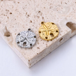 Macro shot of gold and silver starfish pendants on a stone surface for jewelry DIY