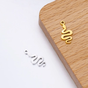 Close-up of gold and silver snake pendants for DIY jewelry with sleek mirror finish