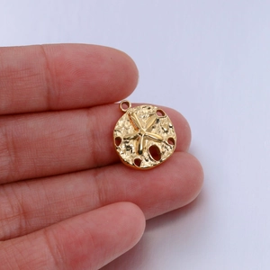 Detailed macro view of a round stainless steel starfish pendant with gold plating