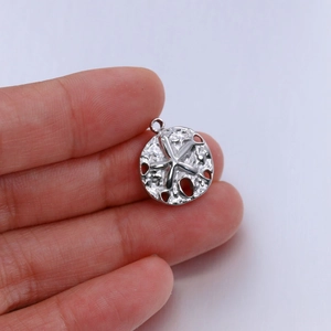 Detailed macro view of a silver starfish pendant with textured cutouts and bail