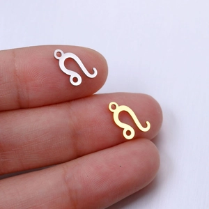 Macro shot of gold and silver Leo zodiac pendant connectors for DIY jewelry making